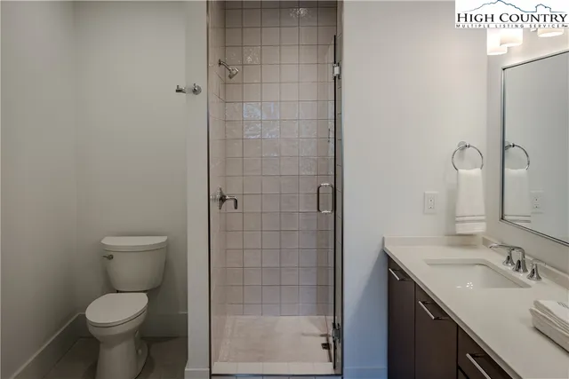 a bathroom with a granite countertop toilet a sink and a mirror
