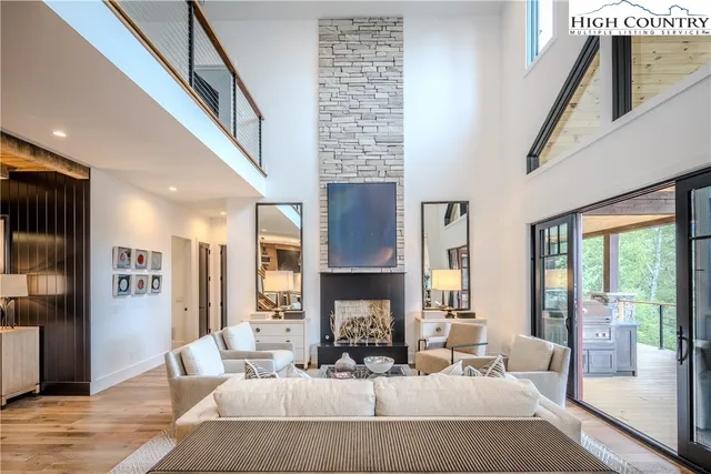 a living room with fireplace furniture and a large window