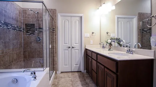 a bathroom with a double vanity sink a large mirror and shower