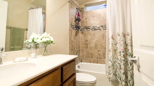 a bathroom with a granite countertop sink a toilet and shower