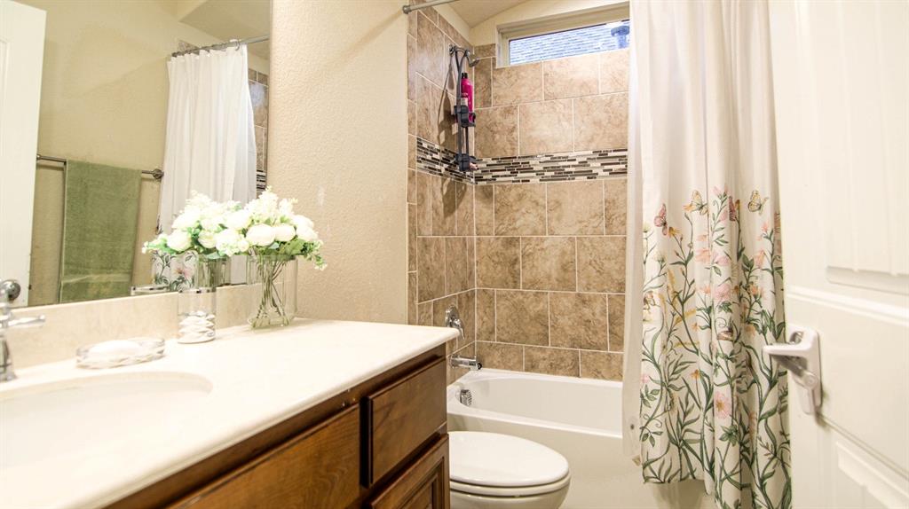 9917 Bodega Bay Road Fort Worth, TX 76177 - Photo 16 of 18 a bathroom with a granite countertop sink a toilet and shower
