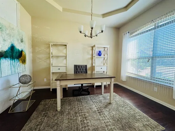 a view of a workspace with furniture and a window