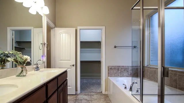 a bathroom with a tub sink and mirror