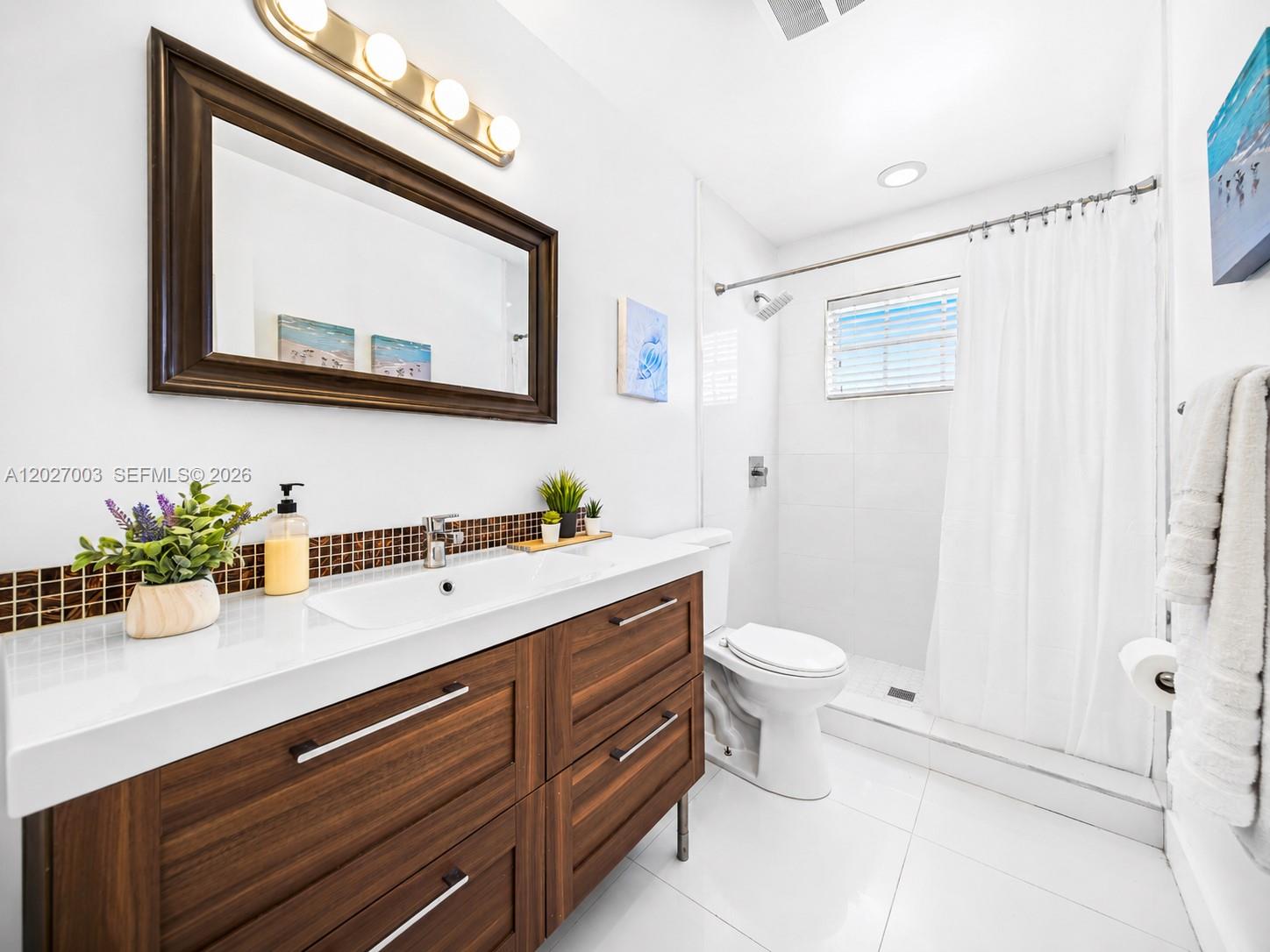 2761 Southwest 92nd Place Miami, FL 33165 - Photo 10 of 37 a bathroom with a toilet sink and mirror