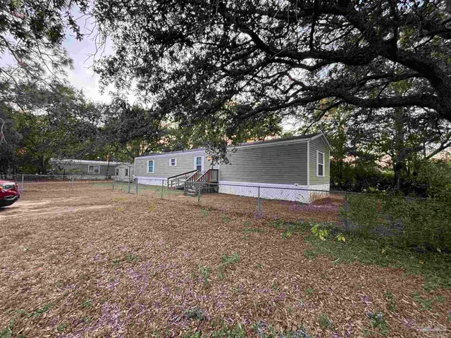 a view of a house with a yard and tree s