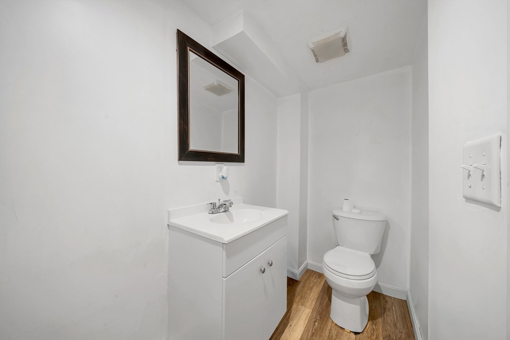 73 Waterhill Street Lynn, MA 01905 - Photo 23 of 33 a bathroom with a toilet sink vanity and mirror
