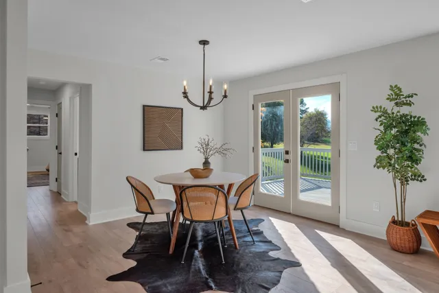 a dining room with furniture potted plants and wooden floor
