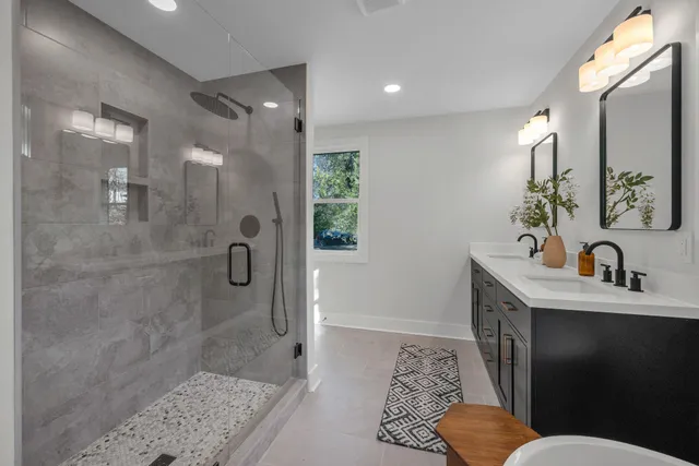 a bathroom with a sink a toilet a shower and a mirror