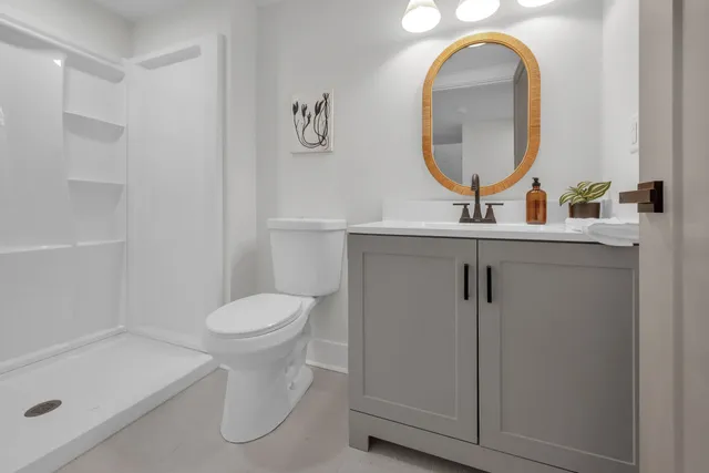 a bathroom with a sink a toilet and a mirror