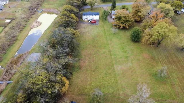 an aerial view of a house with a yard and mountain view in back