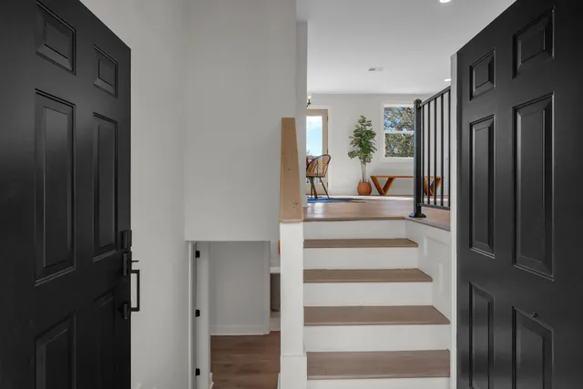 a view of a hallway with wooden floor and windows