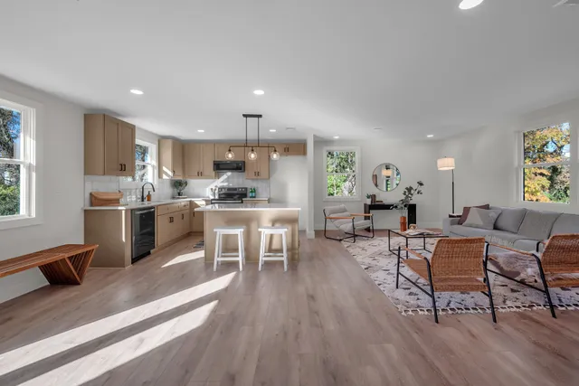 a living room with stainless steel appliances kitchen island granite countertop lots of furniture a dining table and chairs