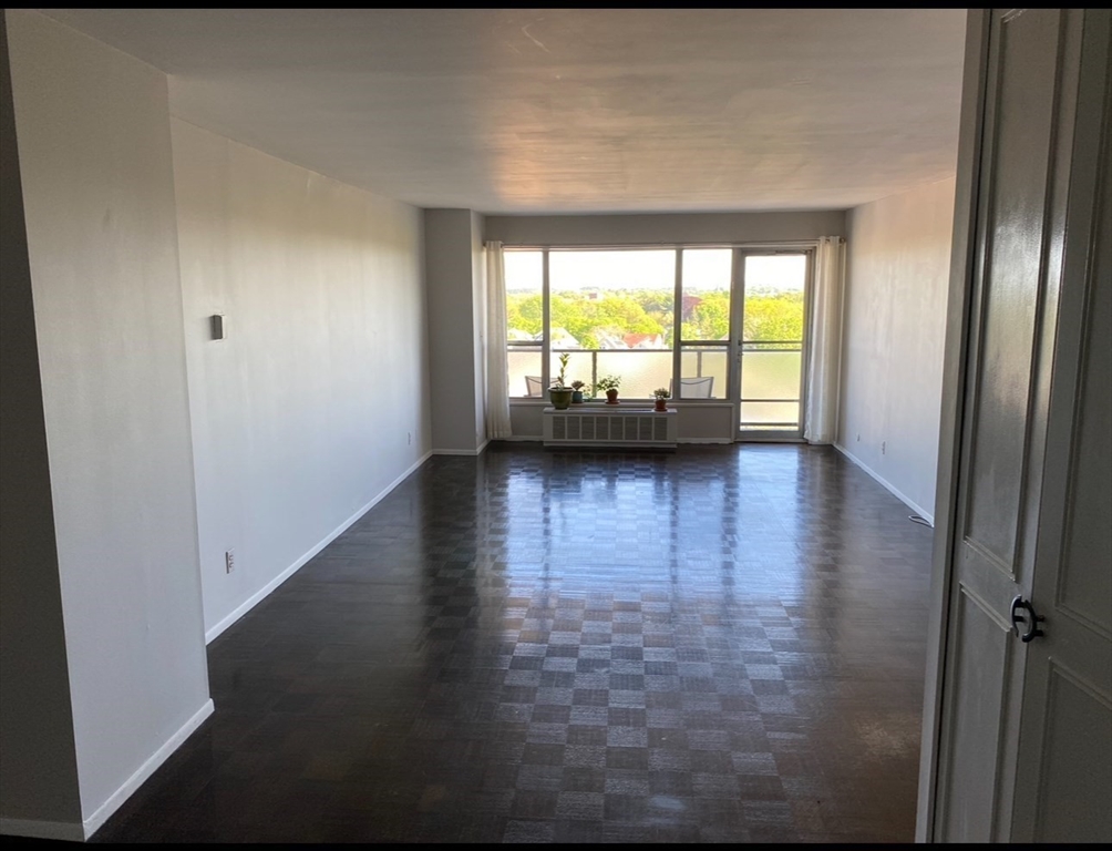111 Perkins Street, Unit 108 Boston, MA 02130 - Photo 6 of 11 a view of empty room with wooden floor and fan