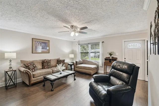 a living room with furniture and a ceiling fan