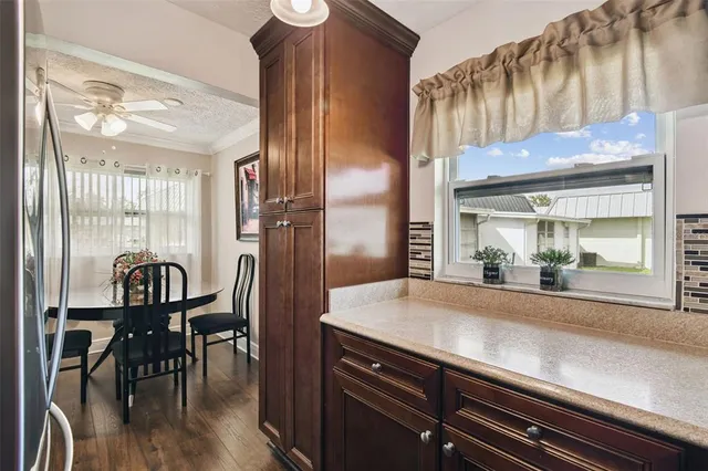 a kitchen with stainless steel appliances granite countertop a refrigerator and a view of living room
