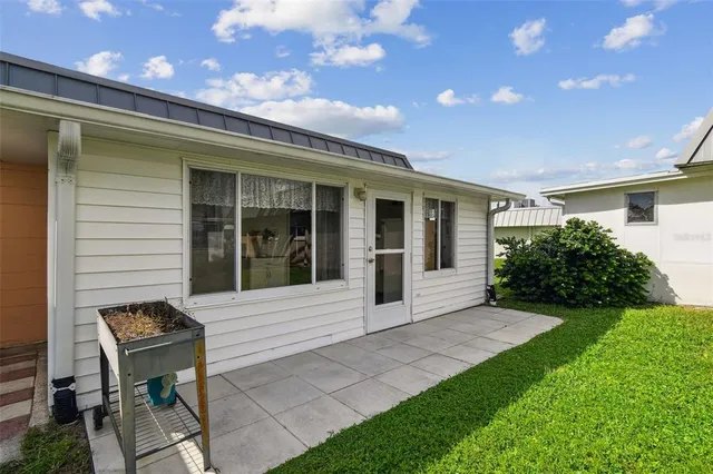 a backyard of a house with table and chairs