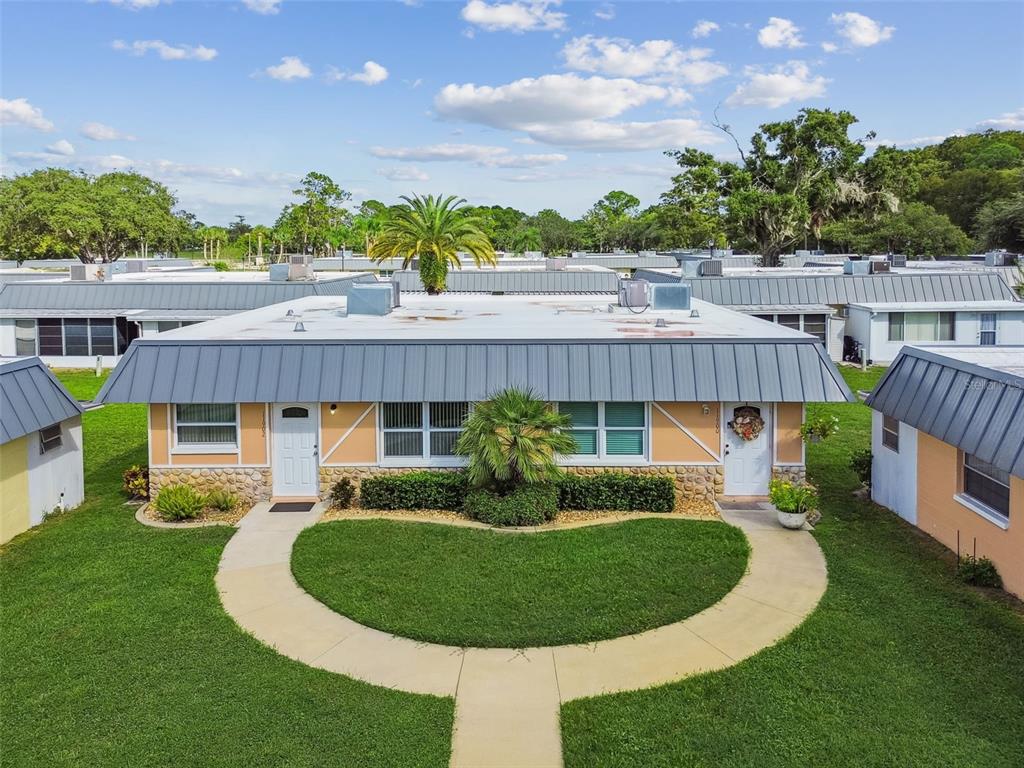 11902 Boynton Lane New Port Richey, FL 34654 - Photo 30 of 44 a view of a house with a swimming pool and a garden