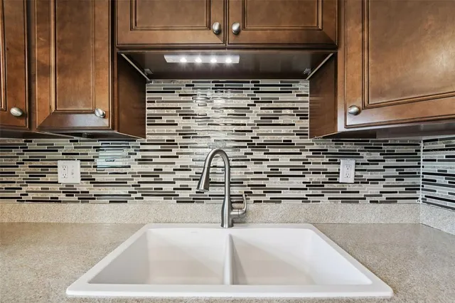 a kitchen with kitchen island a sink a stove and cabinets