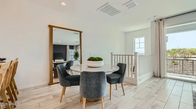 a kitchen with stainless steel appliances granite countertop a dining table chairs refrigerator and microwave