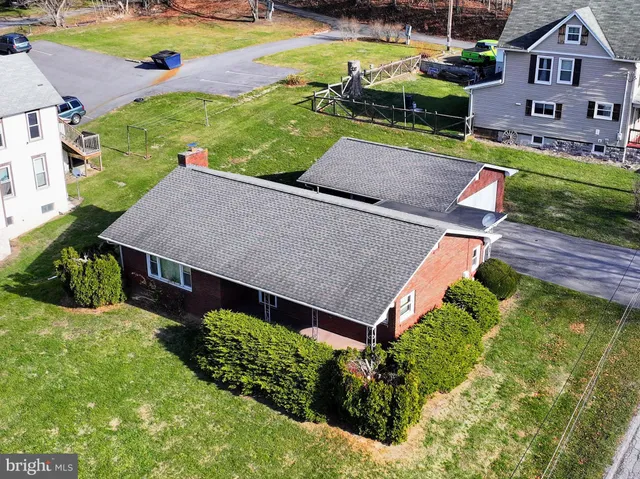 an aerial view of a house with garden space and street view