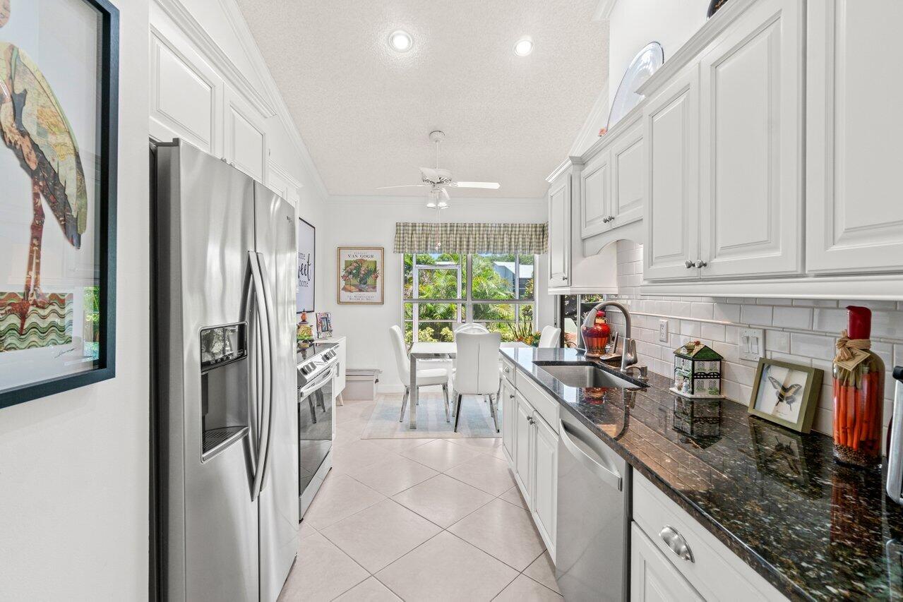 5158 Windsor Parke Drive Boca Raton, FL 33496 - Photo 4 of 44 a kitchen with stainless steel appliances granite countertop a refrigerator sink and cabinets