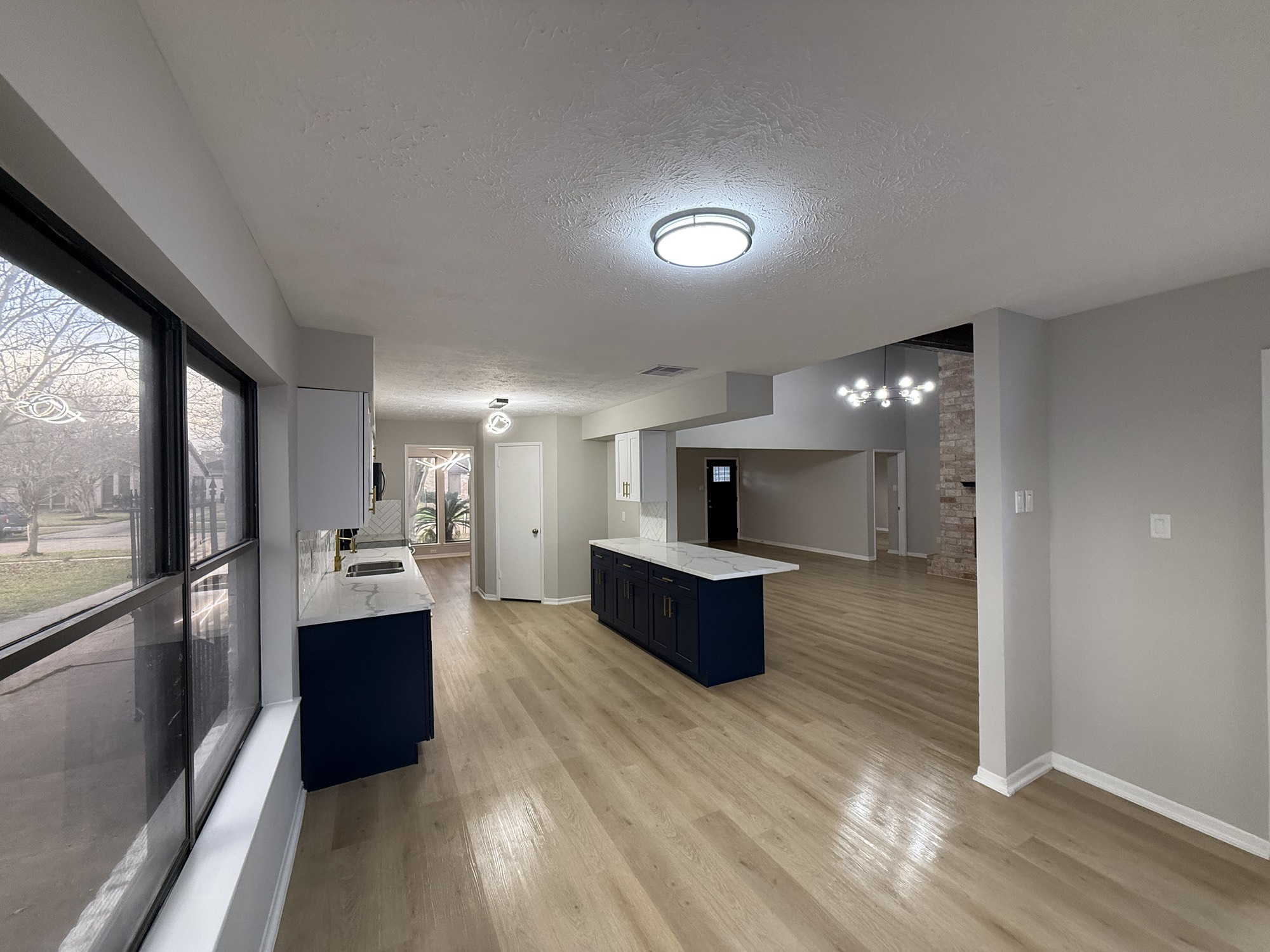 10130 Sagedale Drive Houston, TX 77089 - Photo 9 of 36 a living room with stainless steel appliances kitchen island granite countertop a couch a large window and wooden floor