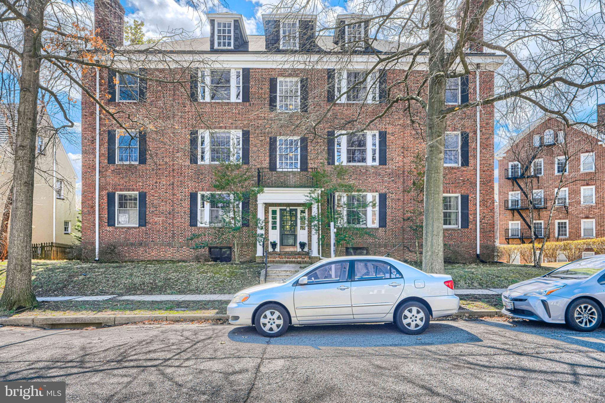 a front view of a residential apartment building with parking space