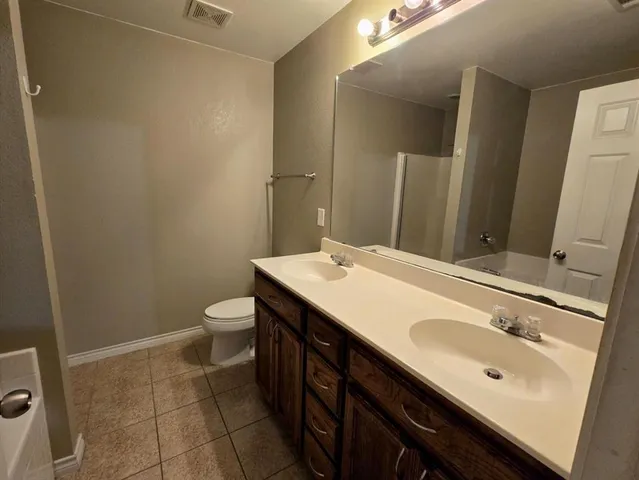 a bathroom with a sink a toilet and mirror
