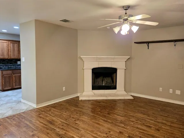 a view of a livingroom with a fireplace a chandelier and wooden floor