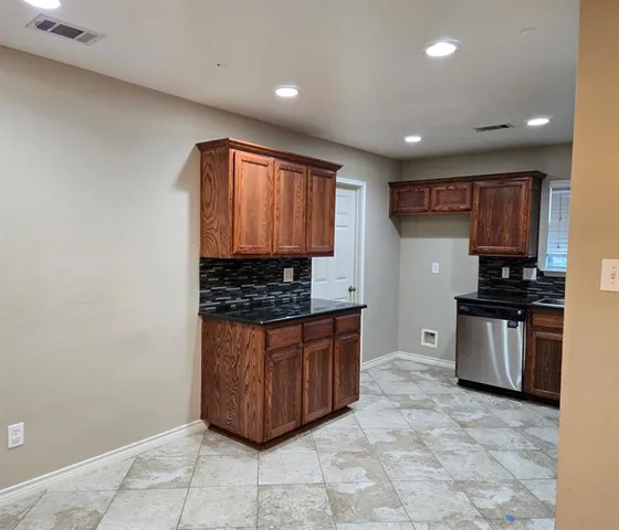 a kitchen with stainless steel appliances granite countertop a stove a sink and a refrigerator