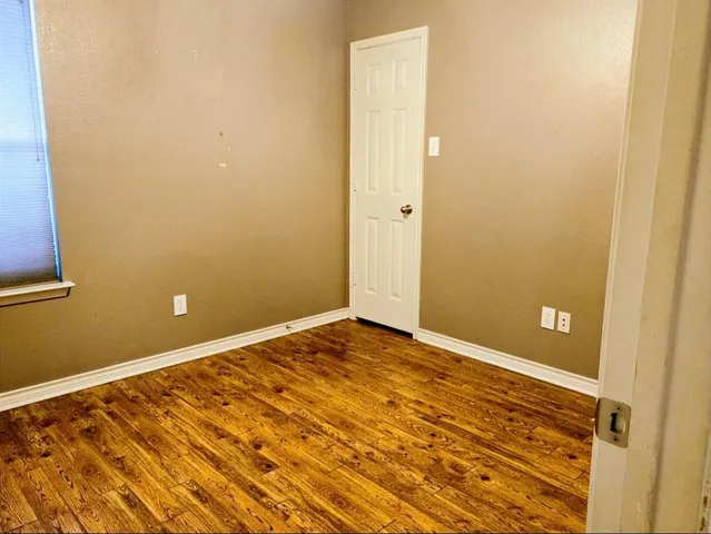 a view of a room with wooden floor and bathroom