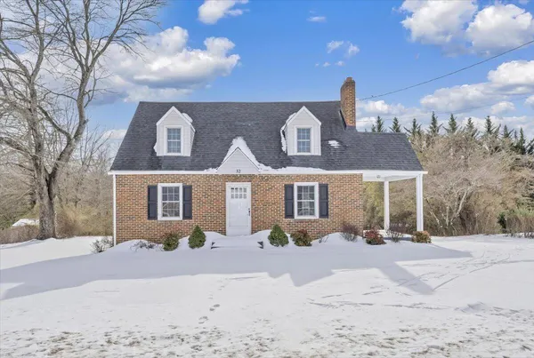 a front view of a house with a yard covered in snow