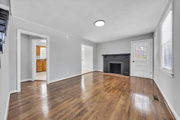 an empty room with wooden floor and fireplace