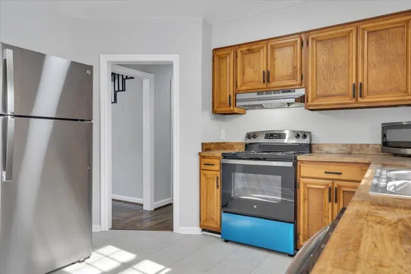 a kitchen with stainless steel appliances granite countertop a refrigerator and a stove top oven
