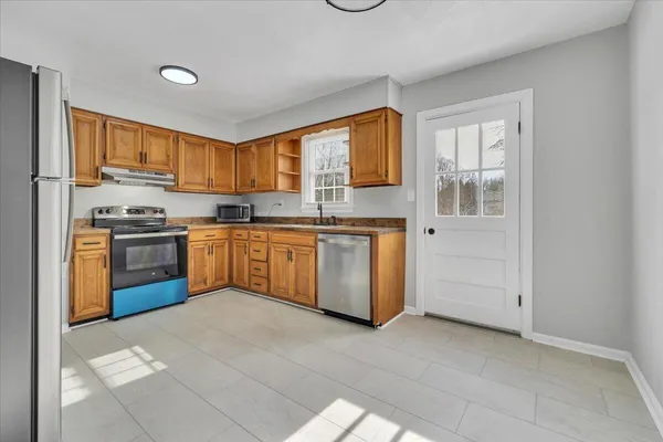 a kitchen with a stove sink and cabinets