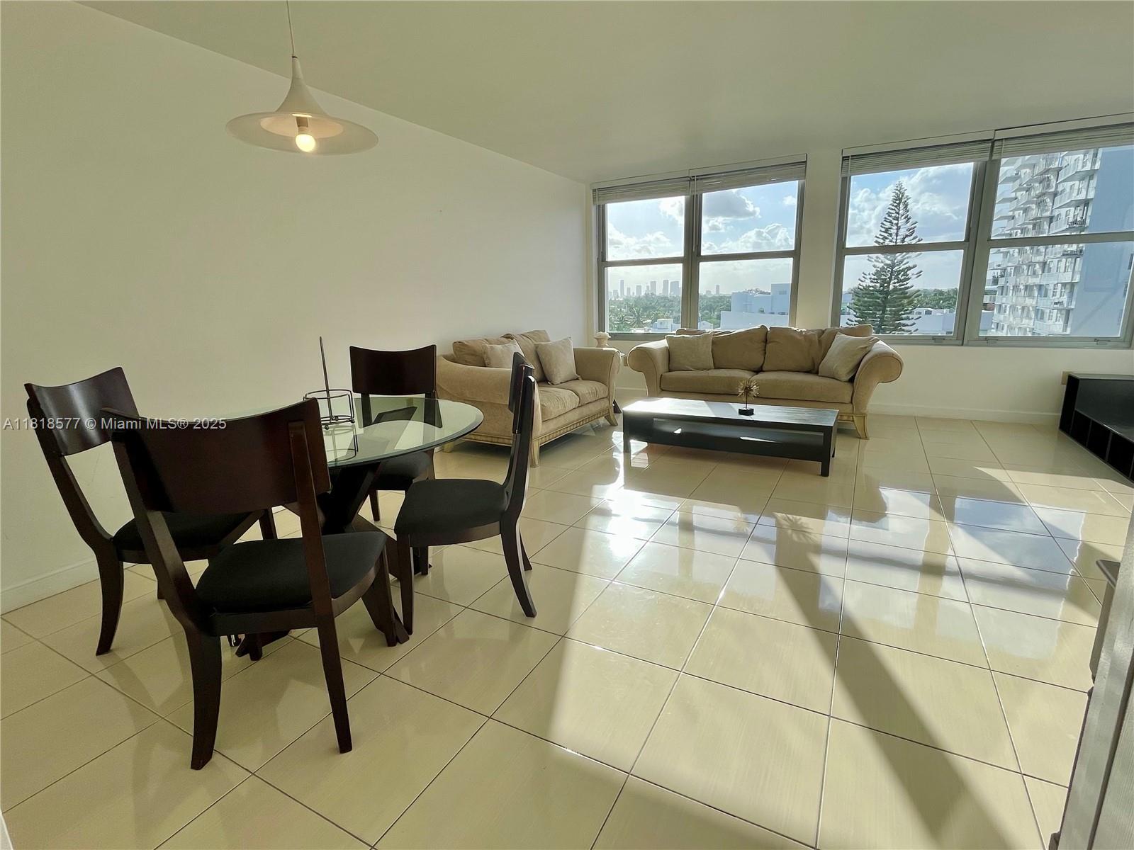 2899 Collins Avenue, Unit 810 Miami Beach, FL 33140 - Photo 5 of 36 a living room with furniture and a floor to ceiling window