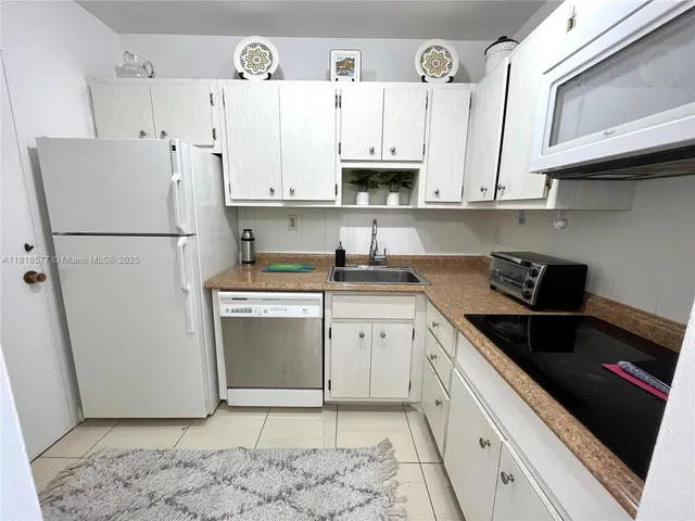 a kitchen with a refrigerator sink and cabinets