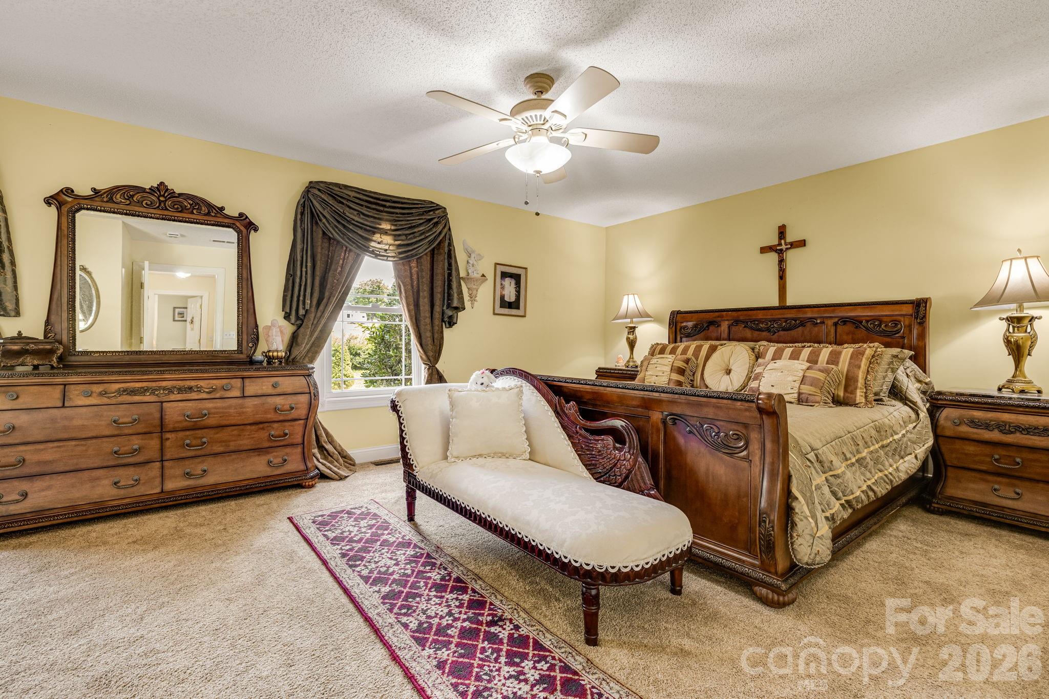 350 Old Sunset Hill Road Hendersonville, NC 28792 - Photo 14 of 40 a bedroom with a bed a chandelier and a dresser