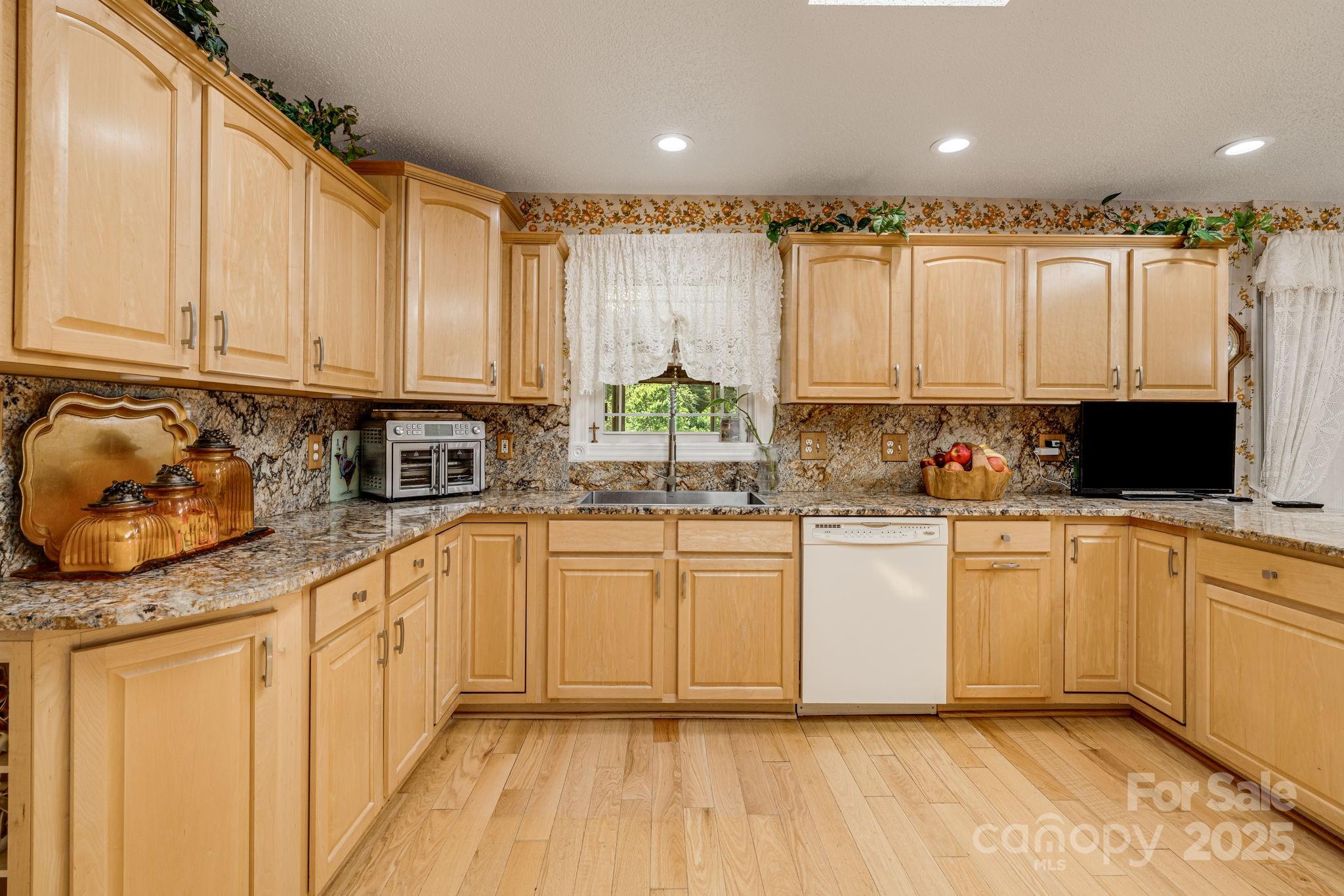 350 Old Sunset Hill Road Hendersonville, NC 28792 - Photo 3 of 40 a kitchen with stainless steel appliances granite countertop a stove a sink and white cabinets