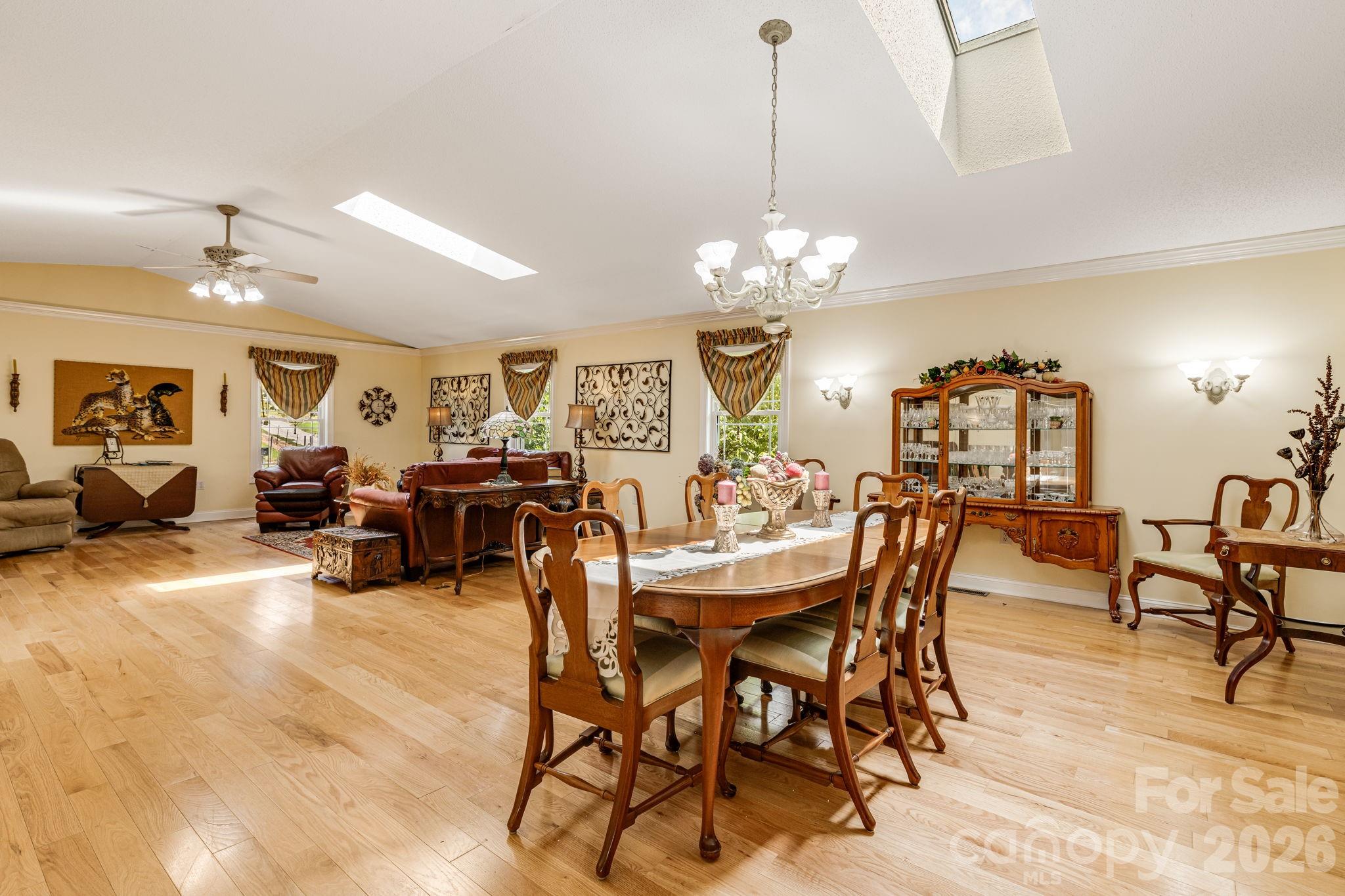350 Old Sunset Hill Road Hendersonville, NC 28792 - Photo 9 of 40 a view of a dining room and livingroom with furniture a chandelier and wooden floor
