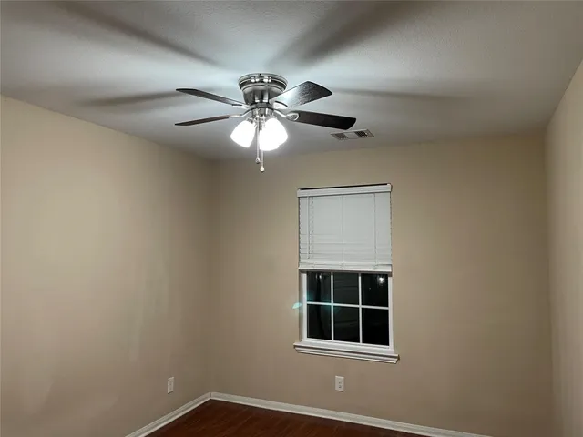 a view of a room with a window and ceiling fan