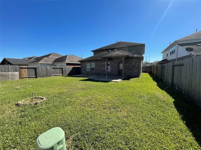 a view of a big house with a big yard and large trees