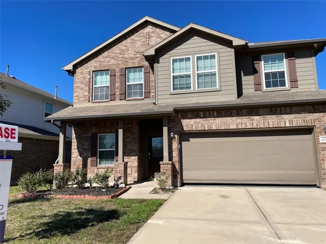 a view of a white house with large windows and a small yard