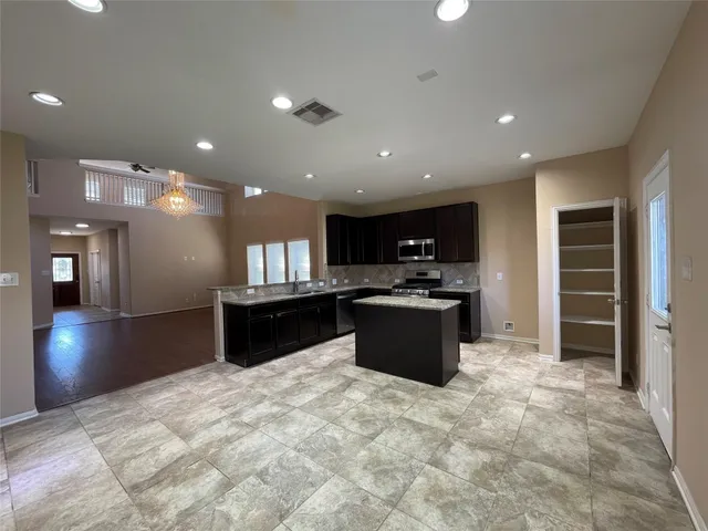 a large kitchen with a large counter top and stainless steel appliances