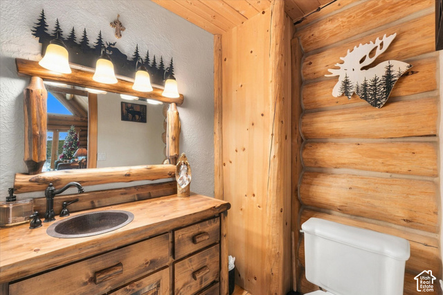 1701 Oak Road Coalville, UT 84017 - Photo 34 of 71 Wood-finish vanity with an oval vessel sink, bronze-finish faucet, and coordinating wood-frame mirror