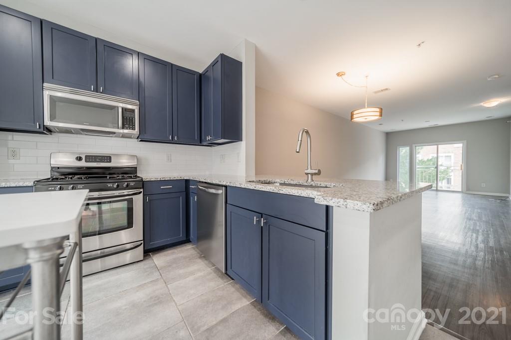 632 Raphael Place Charlotte, NC 28205 - Photo 14 of 37 a kitchen with stainless steel appliances granite countertop a stove a sink and a microwave