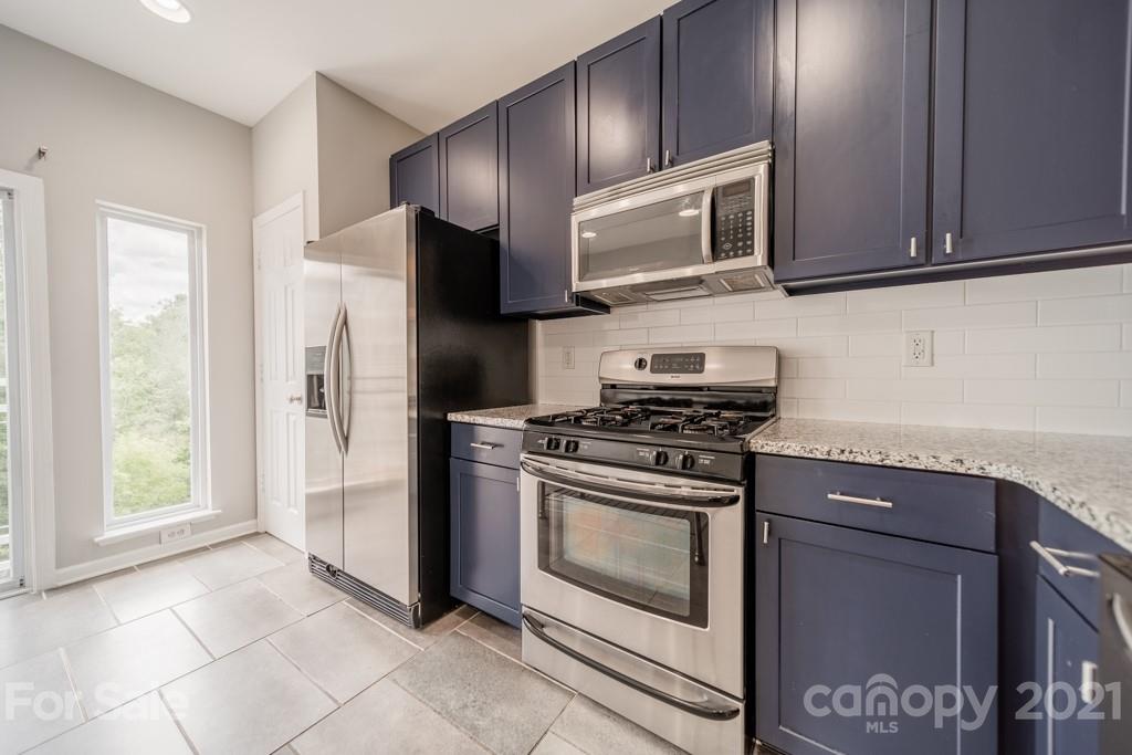 632 Raphael Place Charlotte, NC 28205 - Photo 15 of 37 a kitchen with stainless steel appliances granite countertop a stove microwave and refrigerator