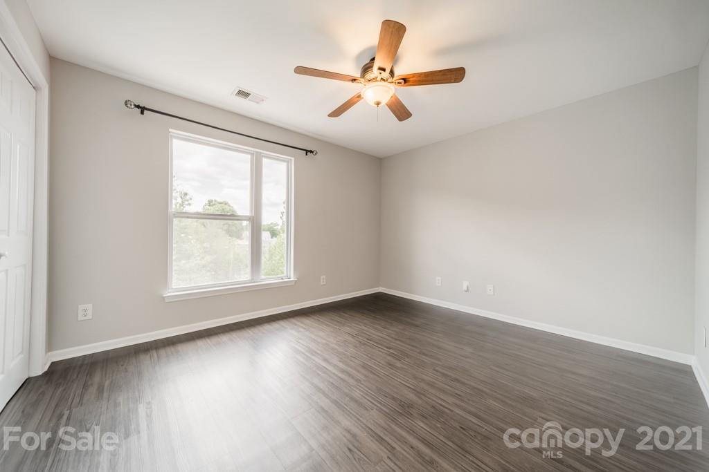 632 Raphael Place Charlotte, NC 28205 - Photo 22 of 37 an empty room with wooden floor fan and windows