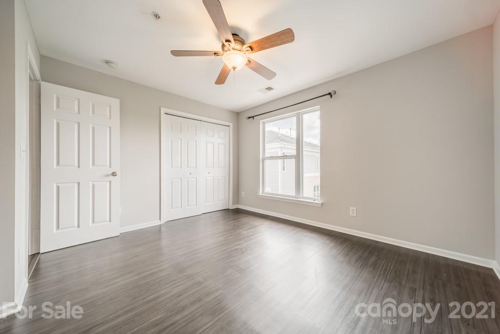 632 Raphael Place Charlotte, NC 28205 - Photo 23 of 37 an empty room with wooden floor chandelier fan and windows