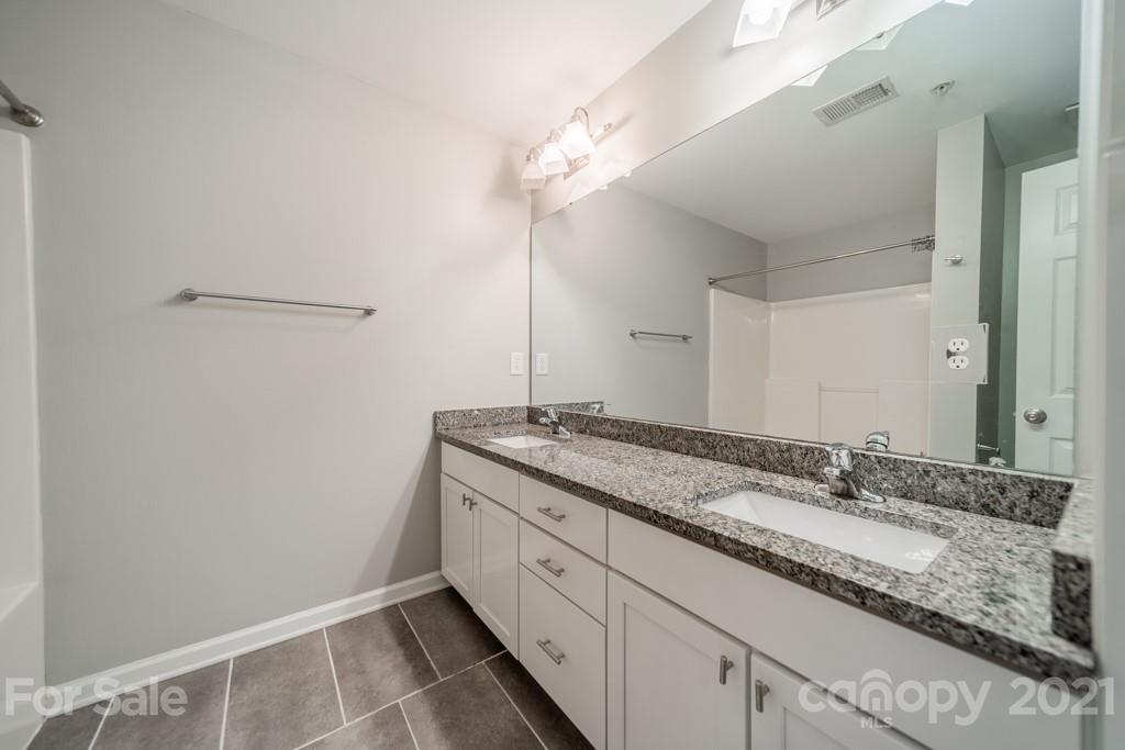 632 Raphael Place Charlotte, NC 28205 - Photo 28 of 37 a bathroom with a granite countertop sink and a mirror